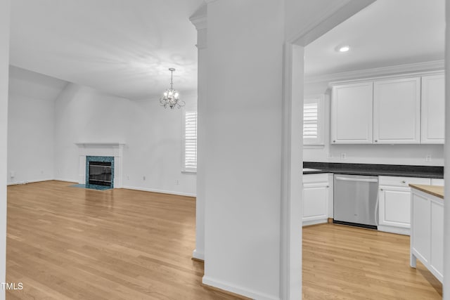 500 Center Pointe Dr, Cary, NC 27513 - kitchen with stainless steel dishwasher, light wood-style floors, white cabinetry, a high end fireplace, and a chandelier