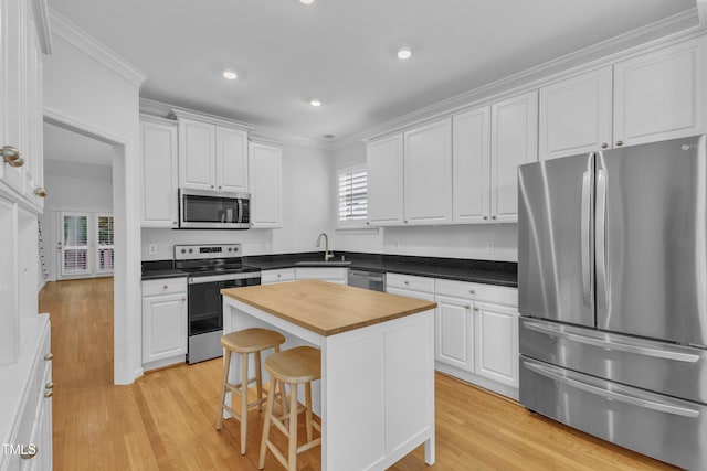 500 Center Pointe Dr, Cary, NC 27513 - kitchen featuring appliances with stainless steel finishes, wooden counters, light wood-style flooring, white cabinets, and crown molding