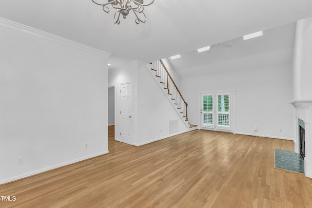 500 Center Pointe Dr, Cary, NC 27513 - unfurnished living room featuring stairway, light wood-style flooring, baseboards, a chandelier, and crown molding