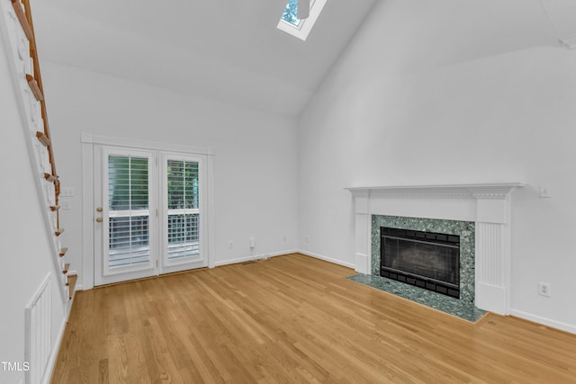 500 Center Pointe Dr, Cary, NC 27513 - unfurnished living room featuring a skylight, wood finished floors, a high end fireplace, high vaulted ceiling, and baseboards