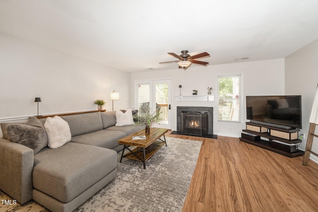 4604 Townesbury Ln, Raleigh, NC 27612 - living area featuring wood finished floors, a ceiling fan, a fireplace with flush hearth, and baseboards