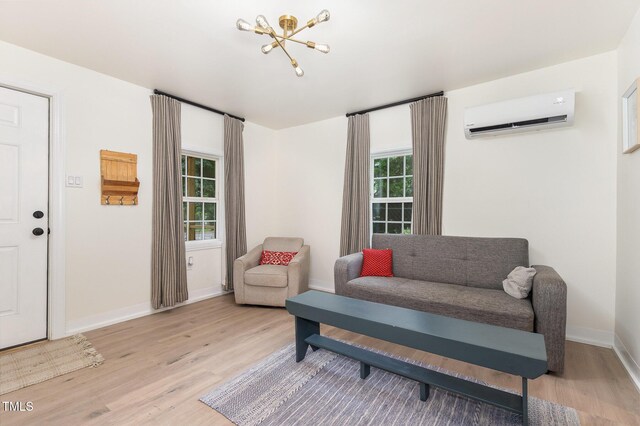 611 Rowland St, Henderson, NC 27536 - living area featuring an AC wall unit, light wood-style floors, and baseboards