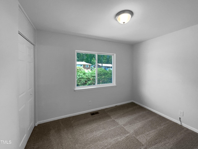 916 Waring St, Durham, NC 27704 - unfurnished bedroom featuring dark colored carpet and a closet