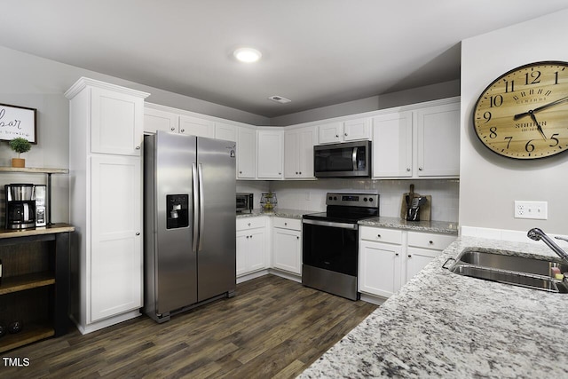 60 Falling Leaf Ln, Benson, NC 27504 - kitchen with stainless steel appliances, a sink, white cabinets, dark wood finished floors, and light stone countertops