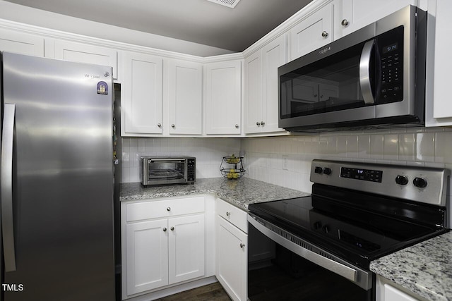 60 Falling Leaf Ln, Benson, NC 27504 - kitchen with appliances with stainless steel finishes, white cabinetry, tasteful backsplash, and light stone countertops