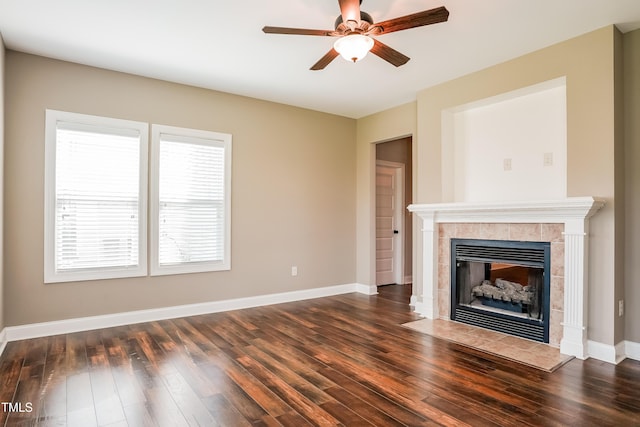67 Bornean Dr, Garner, NC 27529 - unfurnished living room with dark wood-type flooring, a tile fireplace, a ceiling fan, and baseboards
