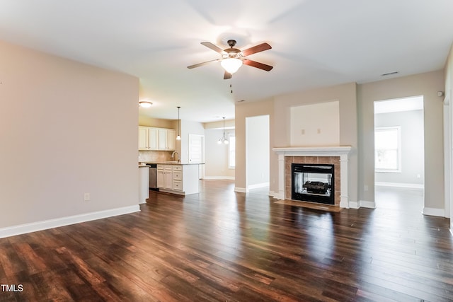 67 Bornean Dr, Garner, NC 27529 - unfurnished living room featuring a sink, ceiling fan, dark wood-type flooring, a fireplace, and baseboards