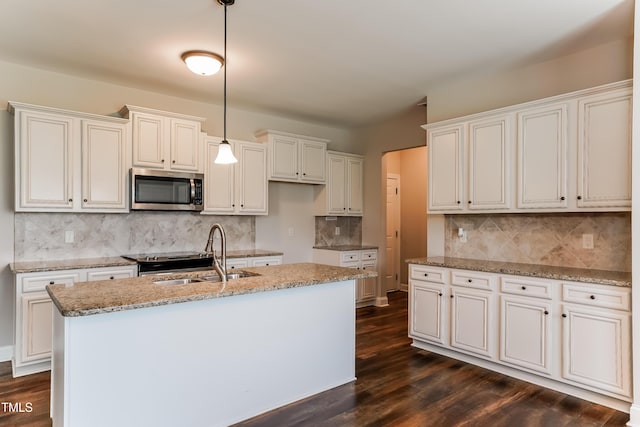 67 Bornean Dr, Garner, NC 27529 - kitchen featuring stainless steel microwave, a sink, light stone countertops, and dark wood finished floors