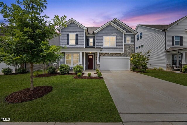 4508 Valley Crest Ln, Fuquay Varina, NC 27526 - view of front facade featuring stone siding, concrete driveway, a garage, and a yard