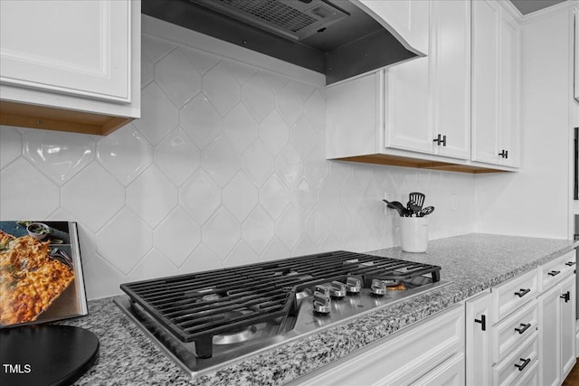4508 Valley Crest Ln, Fuquay Varina, NC 27526 - kitchen featuring stainless steel gas cooktop, white cabinets, custom range hood, backsplash, and light stone counters
