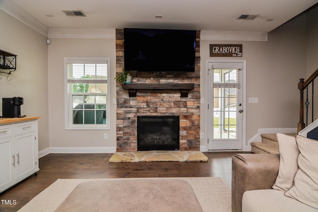 77 Redpine Ct, Clayton, NC 27520 - living area with stairway, ornamental molding, a stone fireplace, dark wood-style flooring, and plenty of natural light