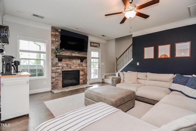 77 Redpine Ct, Clayton, NC 27520 - living room featuring stairway, wood finished floors, a ceiling fan, crown molding, and a stone fireplace