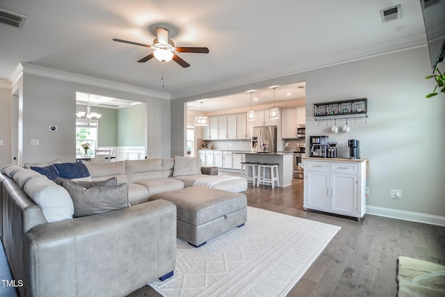 77 Redpine Ct, Clayton, NC 27520 - living area with a ceiling fan, a chandelier, dark wood-type flooring, crown molding, and baseboards