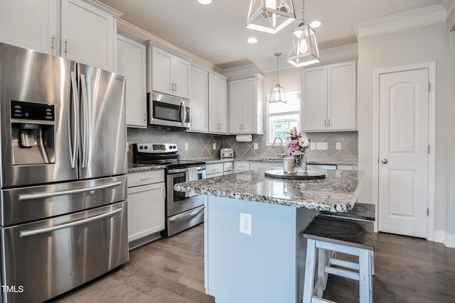 77 Redpine Ct, Clayton, NC 27520 - kitchen featuring appliances with stainless steel finishes, dark wood-style floors, ornamental molding, a breakfast bar, and light stone counters