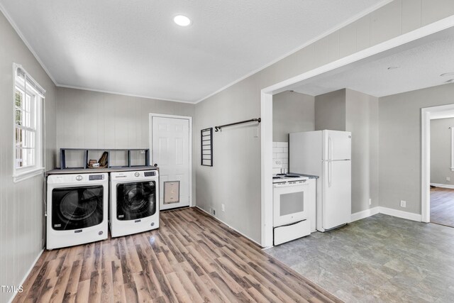 2719 Stratford Dr, Greensboro, NC 27408 - washroom with ornamental molding, washing machine and clothes dryer, baseboards, and light wood-type flooring
