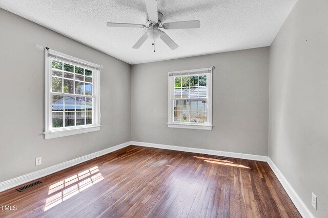 2719 Stratford Dr, Greensboro, NC 27408 - unfurnished room featuring plenty of natural light, wood-type flooring, baseboards, and a textured ceiling