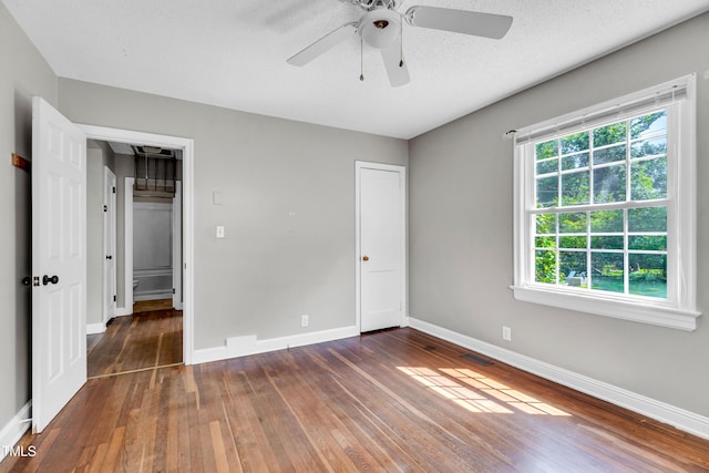 2719 Stratford Dr, Greensboro, NC 27408 - unfurnished bedroom with wood-type flooring, multiple windows, baseboards, and ceiling fan
