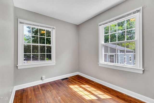 2719 Stratford Dr, Greensboro, NC 27408 - unfurnished room with baseboards, hardwood / wood-style flooring, and healthy amount of natural light
