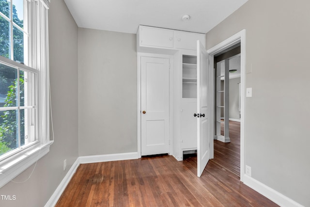 2719 Stratford Dr, Greensboro, NC 27408 - unfurnished bedroom with dark wood finished floors, multiple windows, and baseboards
