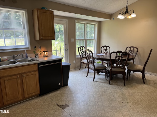 104 Holly Ranch Ct, Willow Springs, NC 27592 - kitchen featuring black dishwasher, plenty of natural light, a textured ceiling, hanging light fixtures, and brown cabinetry