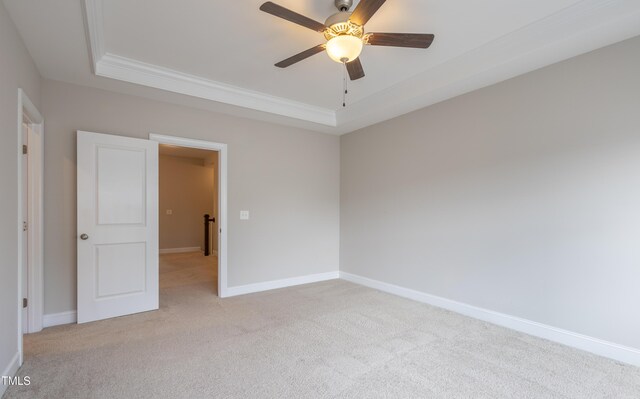 1217 Great Egret Way, Durham, NC 27713 - empty room featuring light colored carpet, a raised ceiling, ornamental molding, baseboards, and ceiling fan