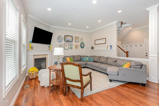 1138 Bexley Hills Bnd, Apex, NC 27502 - living area with light wood finished floors, recessed lighting, stairway, a premium fireplace, and crown molding