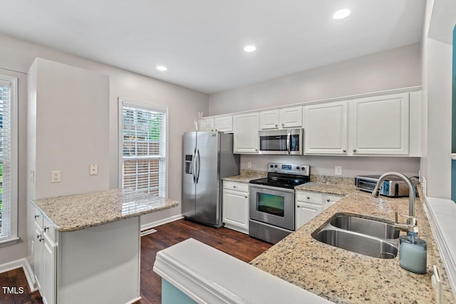 5505 Heather Garden Way, Raleigh, NC 27613 - kitchen with appliances with stainless steel finishes, dark wood-style floors, white cabinetry, recessed lighting, and light stone countertops