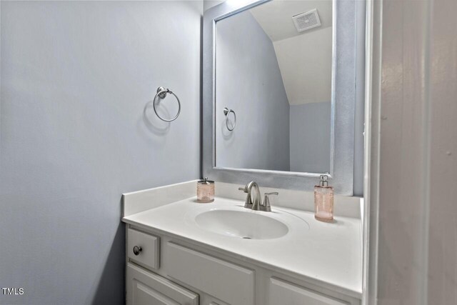5505 Heather Garden Way, Raleigh, NC 27613 - bathroom featuring vanity and vaulted ceiling