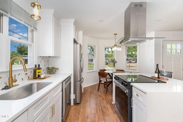 828 Cotton Pl, Raleigh, NC 27601 - kitchen featuring stainless steel appliances, island range hood, a sink, light wood-style floors, and white cabinetry