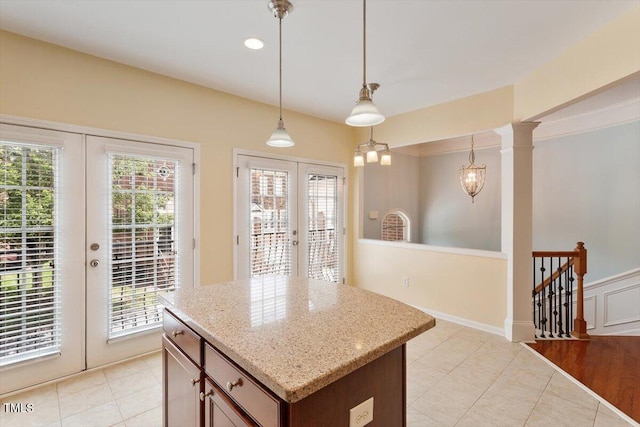 2614 Laurelcherry St, Raleigh, NC 27612 - kitchen with french doors, decorative light fixtures, light tile patterned flooring, light stone countertops, and a center island