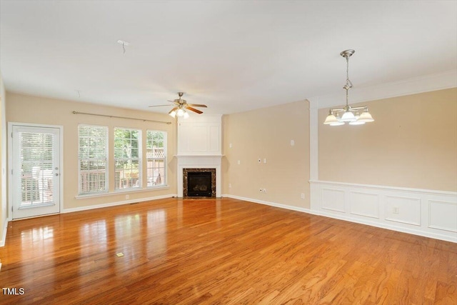 2614 Laurelcherry St, Raleigh, NC 27612 - unfurnished living room with light wood-style floors, ceiling fan, a high end fireplace, and a chandelier