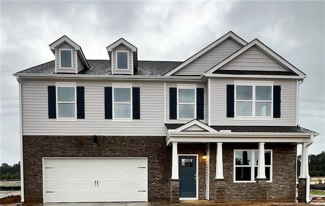 262 Hartfield Ave, Raeford, NC 28376 - view of front of home featuring a garage, brick siding, driveway, and covered porch