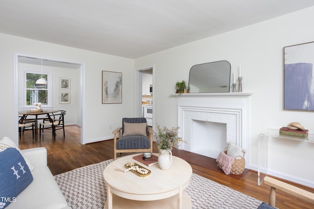 2523 Glendale Ave, Durham, NC 27704 - living room with wood finished floors, a brick fireplace, and baseboards