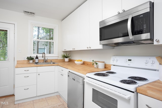 2523 Glendale Ave, Durham, NC 27704 - kitchen featuring stainless steel appliances, a sink, plenty of natural light, and white cabinets