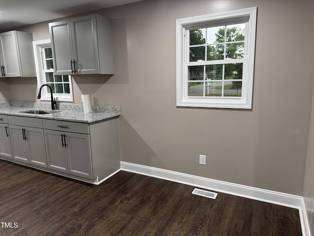 403 Oak St, Roanoke Rapids, NC 27870 - kitchen with a sink, baseboards, dark wood finished floors, gray cabinetry, and light stone countertops