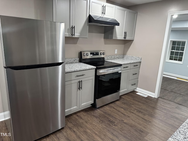 403 Oak St, Roanoke Rapids, NC 27870 - kitchen featuring appliances with stainless steel finishes, under cabinet range hood, dark wood-style flooring, and light stone counters