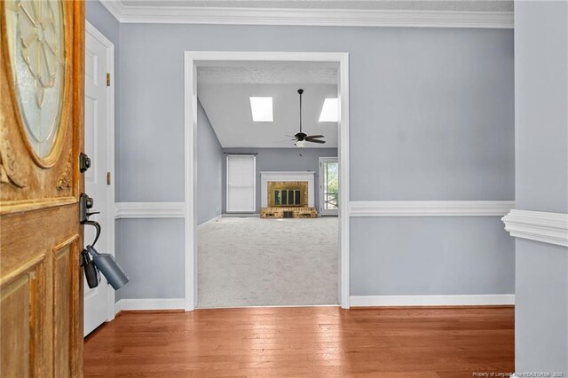 1608 Piney Creek Pl, Fayetteville, NC 28304 - foyer entrance featuring a brick fireplace, a skylight, a ceiling fan, wood finished floors, and baseboards