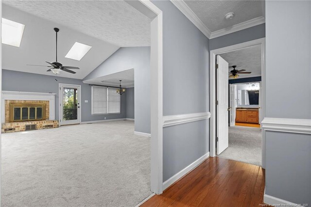 1608 Piney Creek Pl, Fayetteville, NC 28304 - hallway featuring a skylight, a textured ceiling, carpet flooring, baseboards, and lofted ceiling