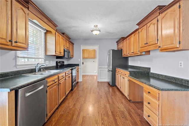 1608 Piney Creek Pl, Fayetteville, NC 28304 - kitchen featuring appliances with stainless steel finishes, a sink, dark countertops, and a textured ceiling