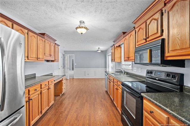 1608 Piney Creek Pl, Fayetteville, NC 28304 - kitchen with black appliances, a sink, dark wood finished floors, a textured ceiling, and dark countertops