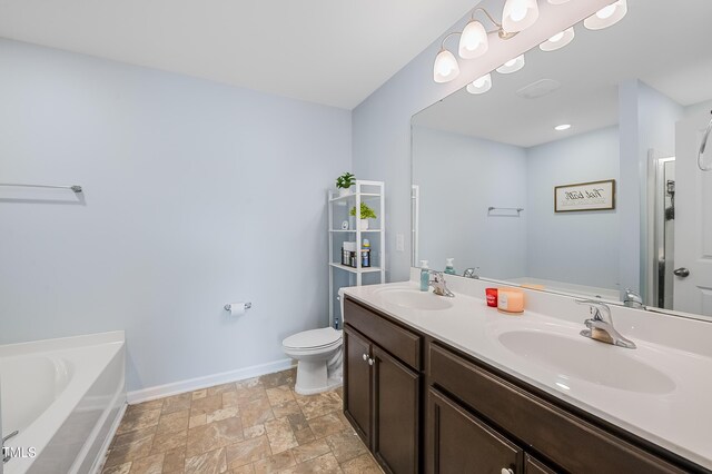 6729 Osprey Landing Dr, Wendell, NC 27591 - bathroom featuring double vanity, baseboards, a bath, toilet, and stone finish flooring