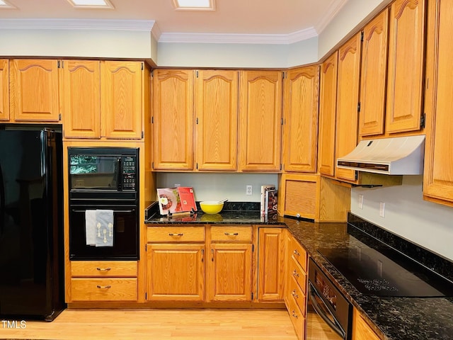 1512 Cumberland Rd, Chapel Hill, NC 27514 - kitchen with black appliances, under cabinet range hood, ornamental molding, dark stone counters, and light wood-style flooring