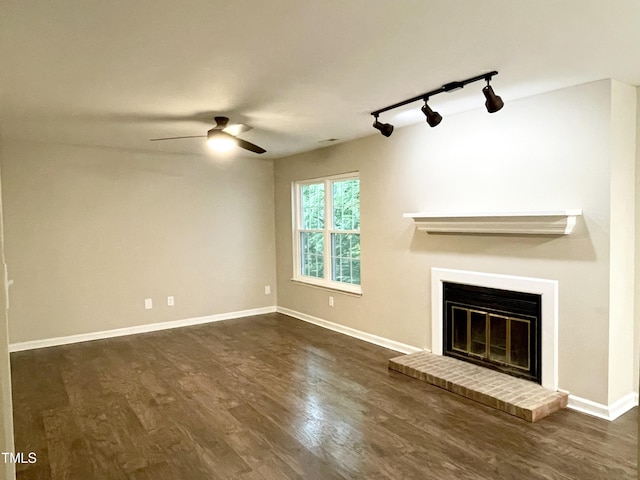 411 Gooseneck Dr Unit A1, Cary, NC 27513 - unfurnished living room with rail lighting, a ceiling fan, a brick fireplace, baseboards, and dark wood finished floors