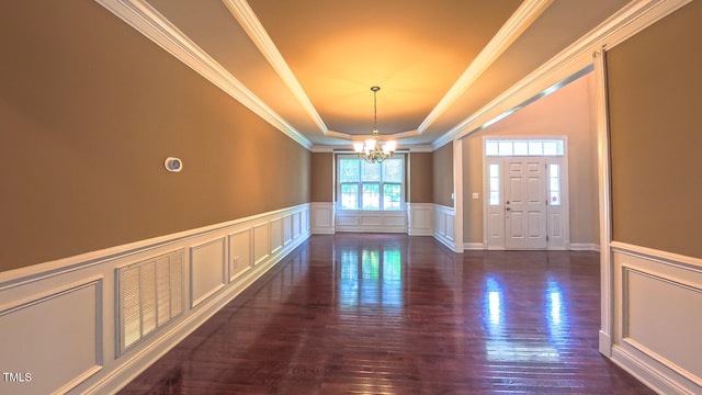 3408 Mount Pisgah Way, Cary, NC 27519 - foyer with a chandelier, a tray ceiling, a decorative wall, dark wood finished floors, and crown molding