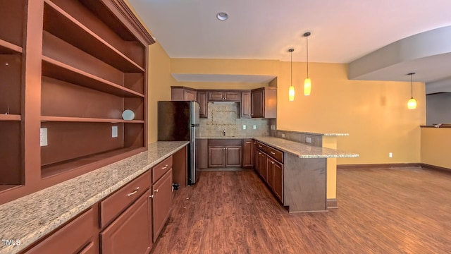 3408 Mount Pisgah Way, Cary, NC 27519 - kitchen featuring freestanding refrigerator, a peninsula, dark wood finished floors, decorative backsplash, and hanging light fixtures