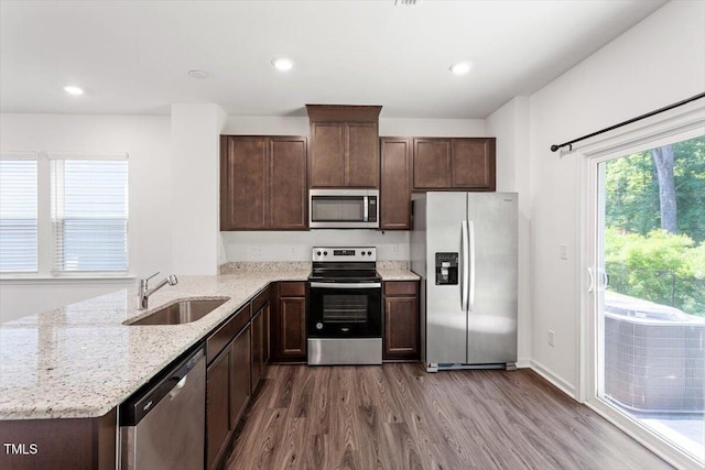3064 Spline Cir, Raleigh, NC 27610 - kitchen featuring stainless steel appliances, a sink, dark wood-style flooring, dark brown cabinetry, and light stone counters