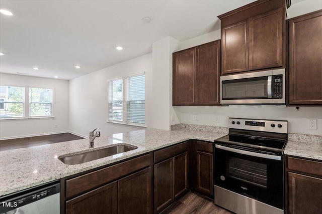 3064 Spline Cir, Raleigh, NC 27610 - kitchen featuring appliances with stainless steel finishes, a sink, dark wood-style floors, dark brown cabinets, and light stone counters