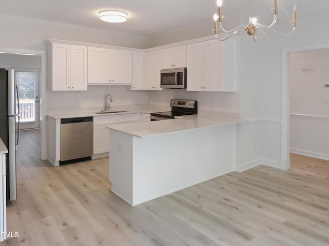 137 Wintermist Dr, Cary, NC 27513 - kitchen with appliances with stainless steel finishes, a sink, light countertops, white cabinetry, and light wood-type flooring