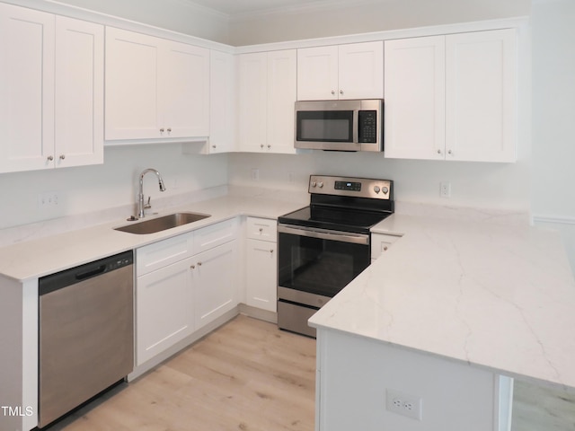 137 Wintermist Dr, Cary, NC 27513 - kitchen featuring appliances with stainless steel finishes, a sink, a peninsula, white cabinetry, and light wood finished floors