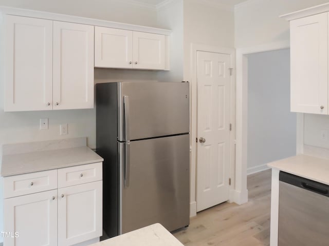 137 Wintermist Dr, Cary, NC 27513 - kitchen featuring stainless steel appliances, crown molding, white cabinets, light wood-style floors, and light stone countertops